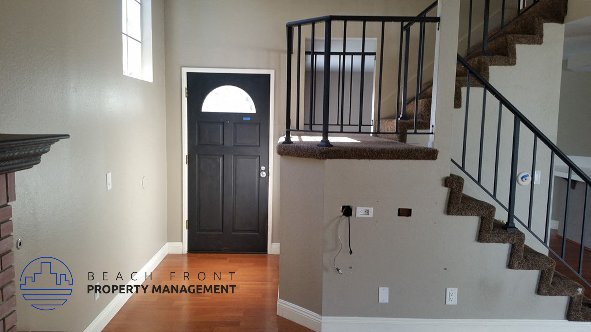 A hallway with a staircase and a door.