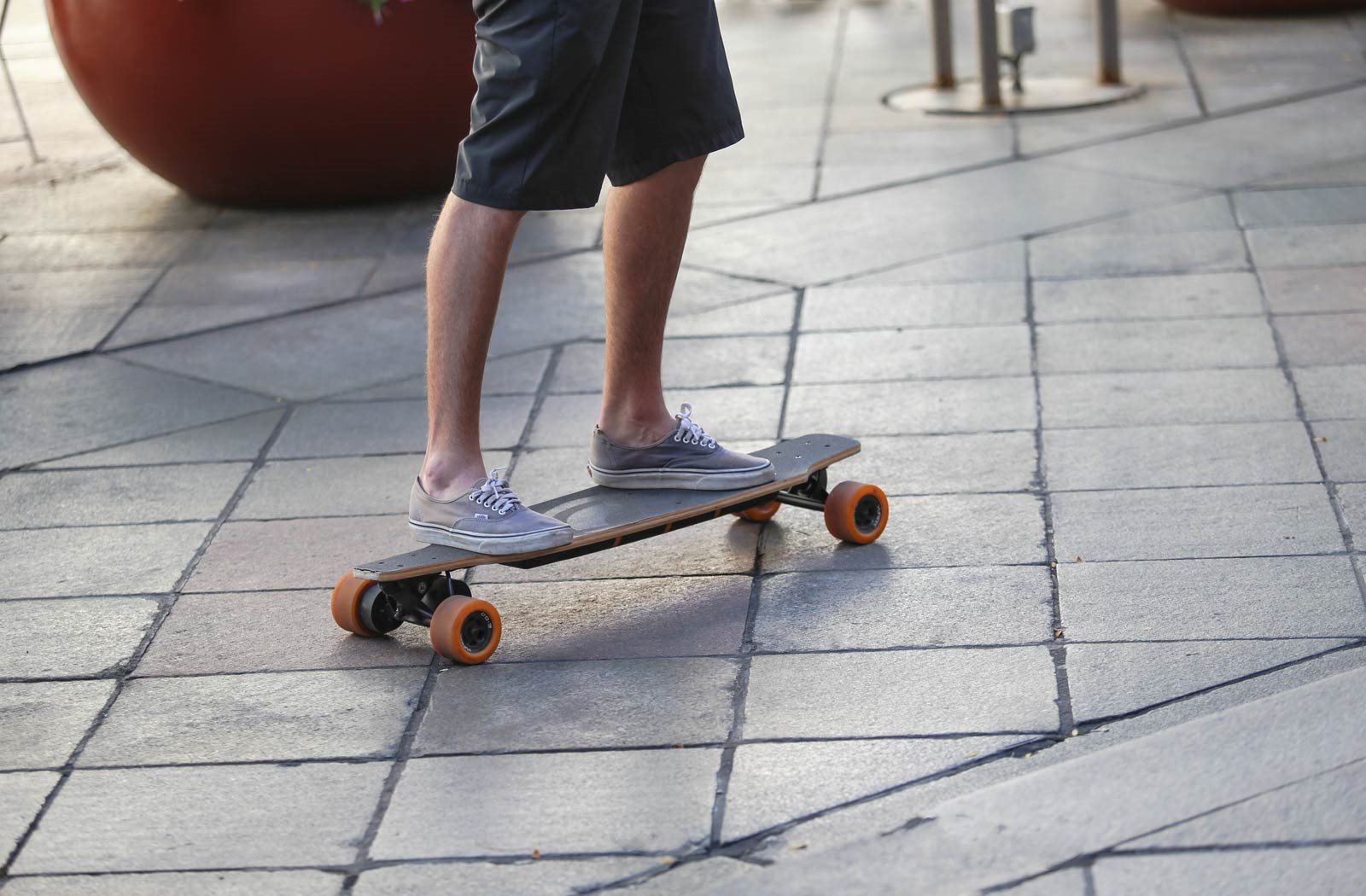 A person is riding a skateboard on a tiled floor.