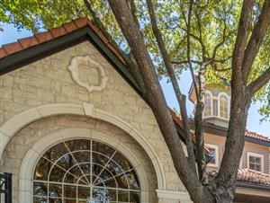 Leasing office entrance under shade trees surrounded by green landscape