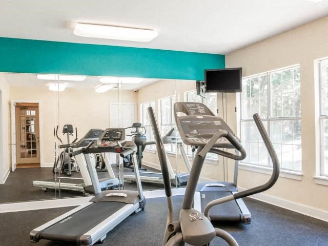 Fitness Center cardio room with large windows and mirrored wall
