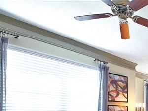 Living room with large window, wood-style flooring and ceiling fan