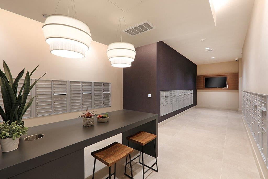Sleek mail room with white flooring, dark wood furniture, and high chairs