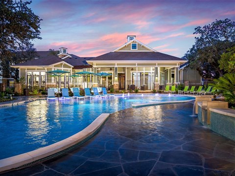 Sunset pool view with poolside seating outside resident clubhouse