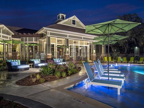 Nighttime pool view with in and poolside lounge seating