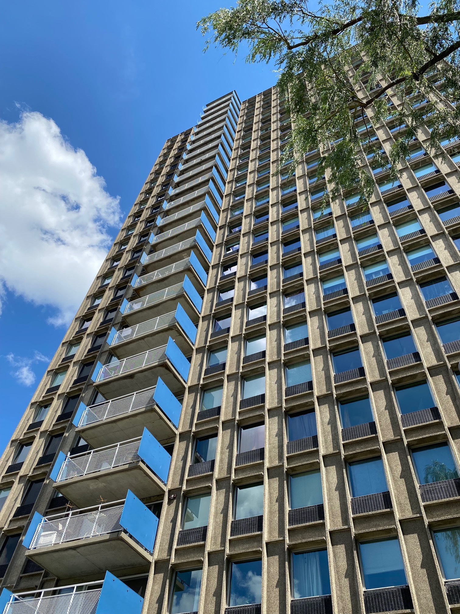 Tall high-rise building with lots of glass and balconies.