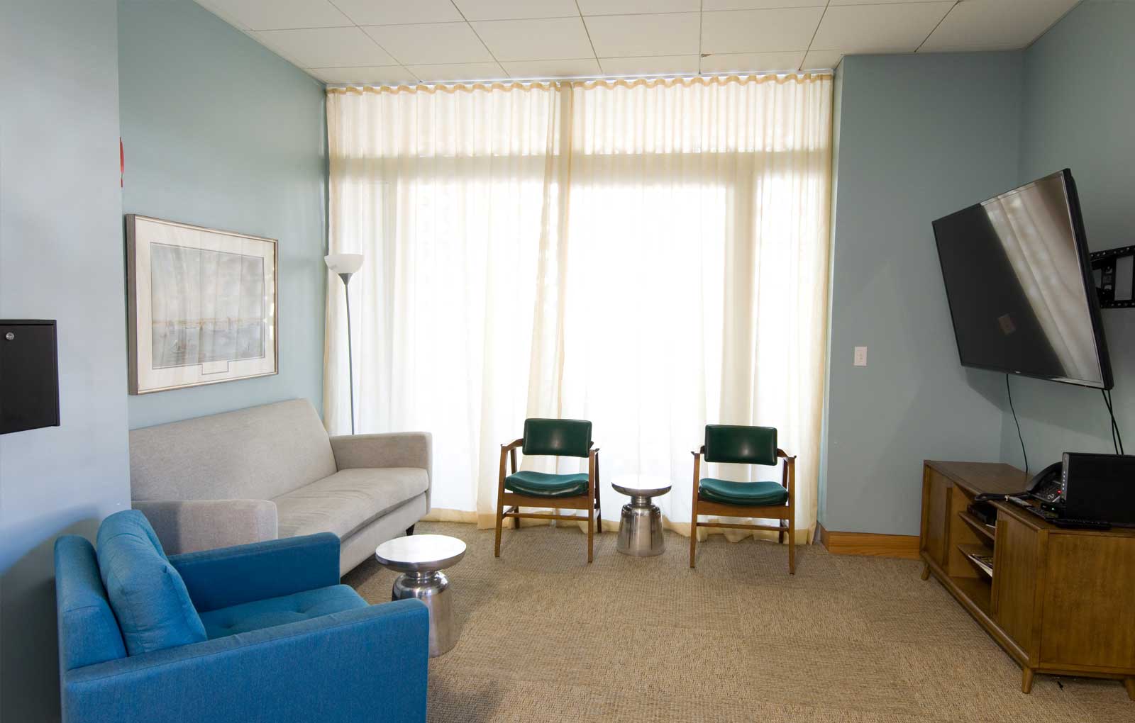 Apartment interior with large bright windows and carpeted floors