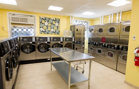 Large bright and clean laundry room with plentiful machines.