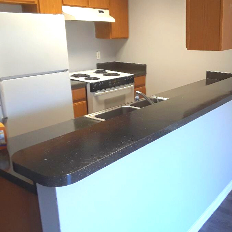 white appliances with light wood cabinets and black granite counter tops