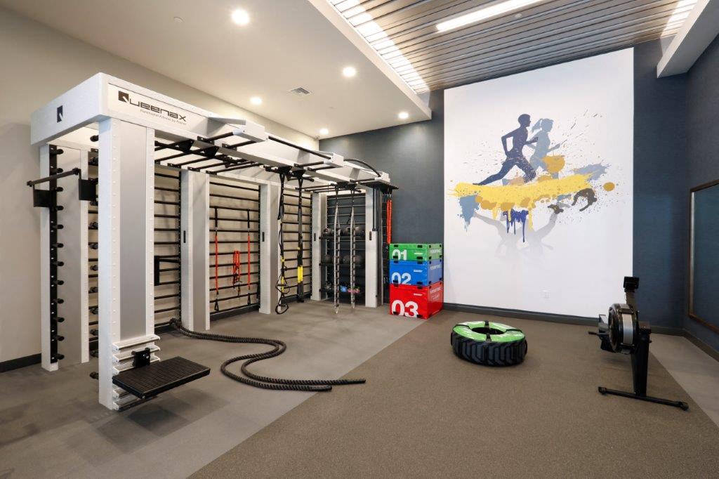 Fitness gym with weights and an artistic painting on the wall