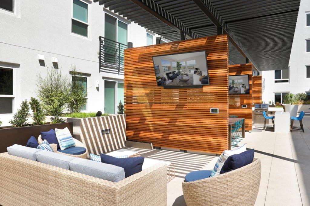 Outdoor lounge with cushioned seating and a modern fireplace