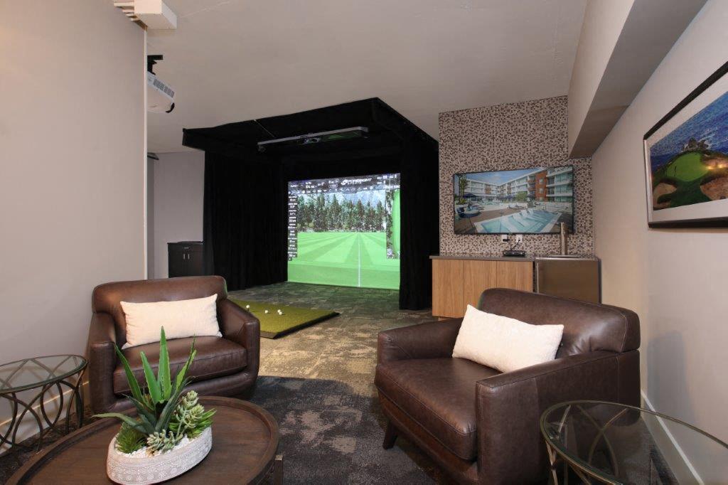 Living room featuring two leather chairs and a view of the high-end Gold Simulator