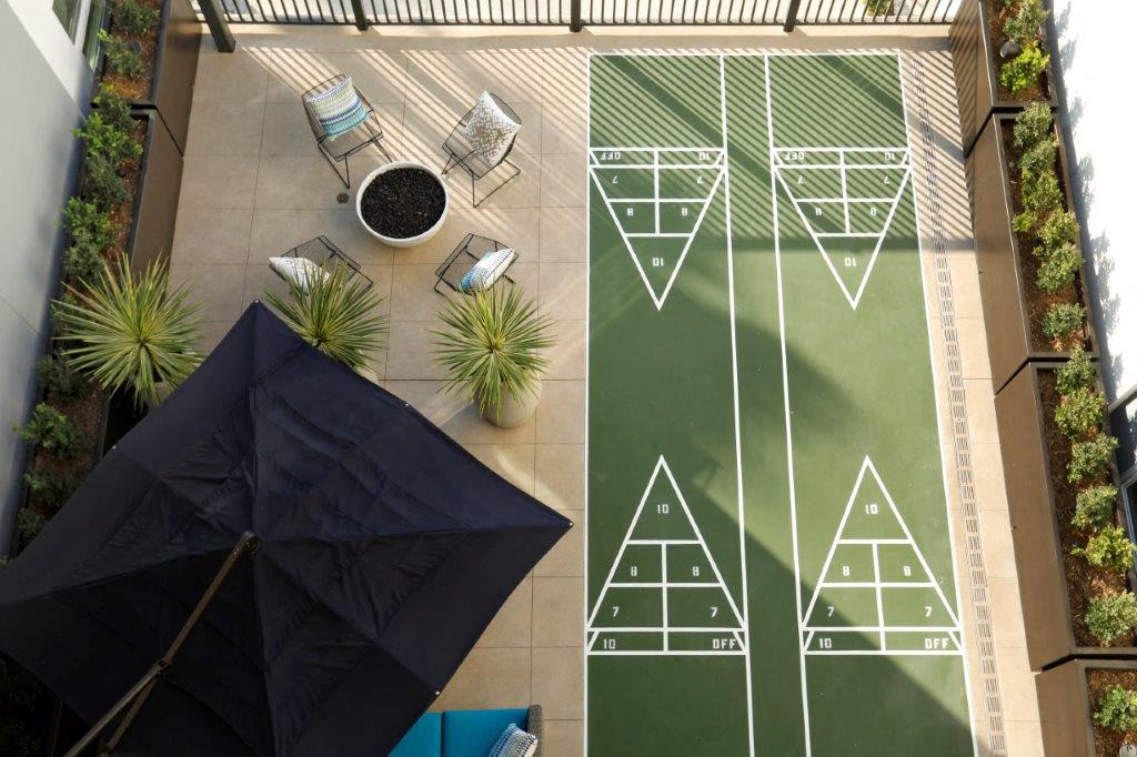 A cozy fire pit surrounded by seating and a shuffleboard court