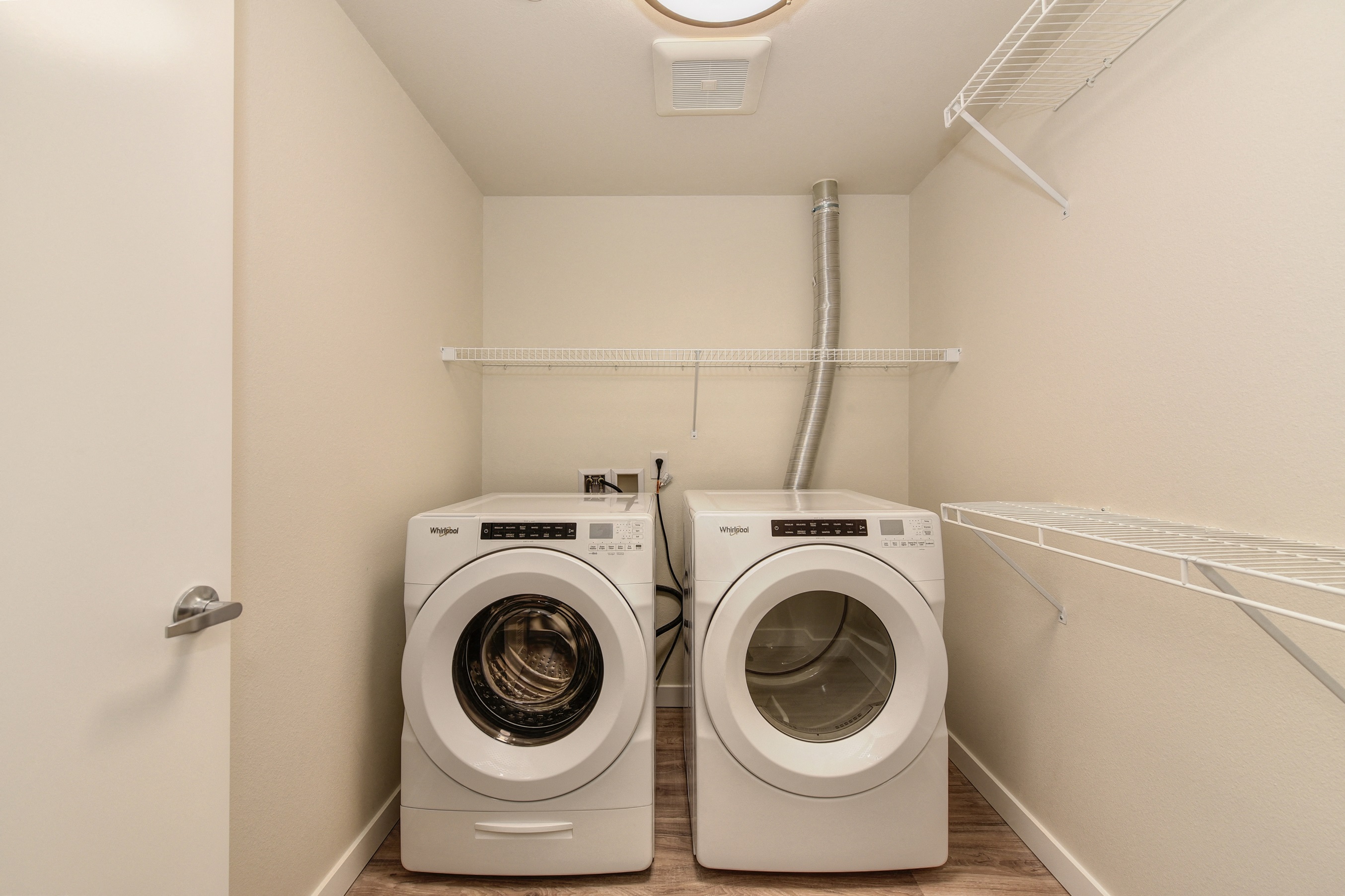 Singular Washer and Dryer Machine Room with White Walls and Shelves